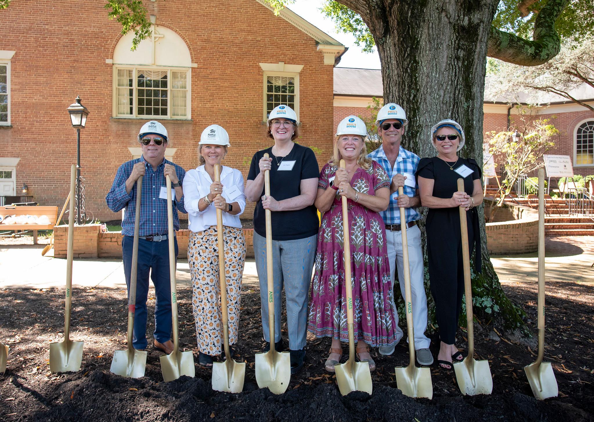 Phil's family and friends at the glebe view groundbreaking. They are wearing hard hats and holding shovels.